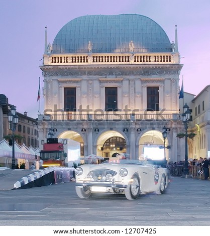 vintage car speeding in a square during race in Brescia