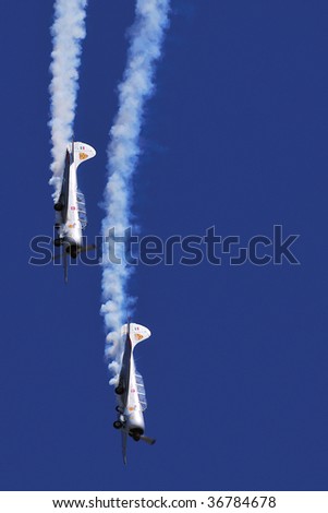 BRESCIA, ITALY - SEPTEMBER 6: two soviet built Yakovlev Yak 52 aircrafts of Yak Italia team diving with trailing smoke during Brixia Air Show.  on September 6, 2009 in Brescia