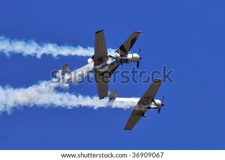 BRESCIA, ITALY - SEPTEMBER 6: three soviet built Yak 52 aircrafts of Yak Italia private team close passage. Notice the top aircraft is upside-down during Brixia Air Show.  on September 6, 2009 Brescia