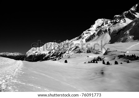 high Val Martello, Italian Alps in winter with ski tracks on the left. Black and white conversion with strong yellow filter to make sky almost black