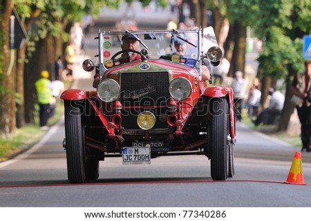 BRESCIA, ITALY - MAY 12 : A 1927 built red OM 665 Superba car meets a control in transit point (time check in a regularity race) during 1000 Miglia race on May 12, 2011 in Brescia.
