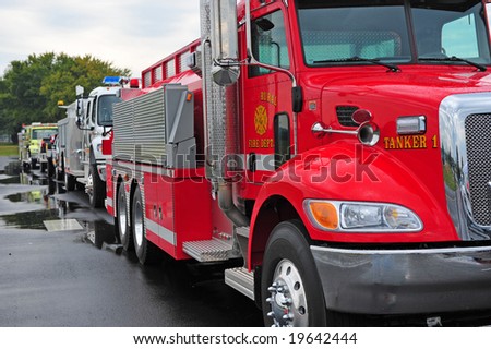 Row of rescue vehicles led by red fire truck