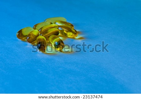 Clear yellow pills on blue background