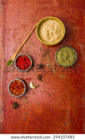 Herbs for cooked with herbs on the red old wooden background.