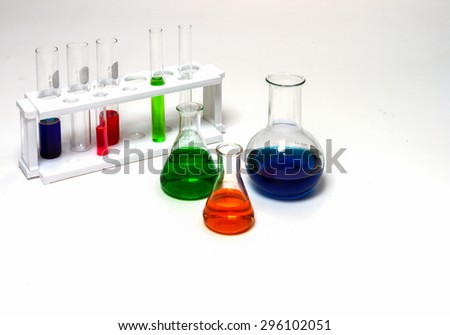 Group of laboratory flasks empty or filled with a clear liquid on white background.