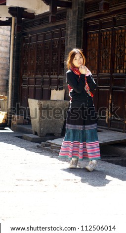 chinese girl model at Lijiang waiting in the street in the old city with long skirt girlfriend