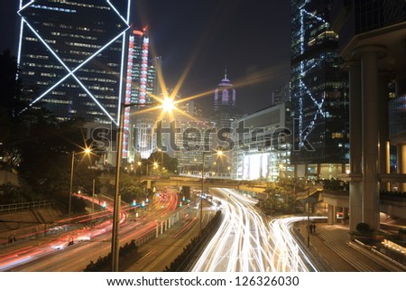 car trails with the building with the landmark of bank of china in hong kong, financial background