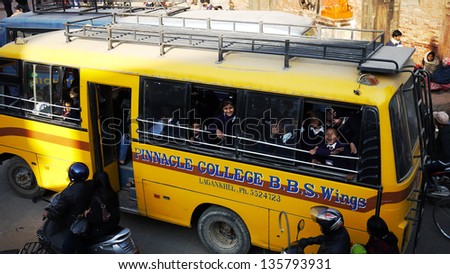 KATHMANDU, NEPAL - JAN. 20: School Bus students say hello in Nepal on January 20, 2010. Children from poor families are leaving schools as their parents can\'t afford to keep them in the schools
