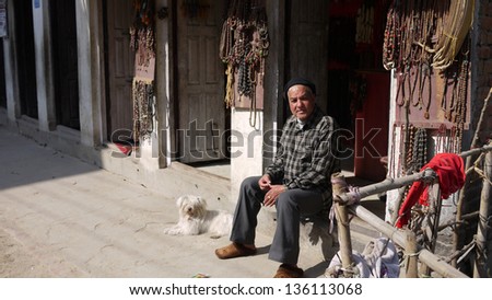KATHMANDU, NEPAL - JANUARY 20: an unidentified old man take a rest with his dog in kathmandu suburb on 20 jan 2010. the United Nations list Nepal as one of the Least developed country in the world