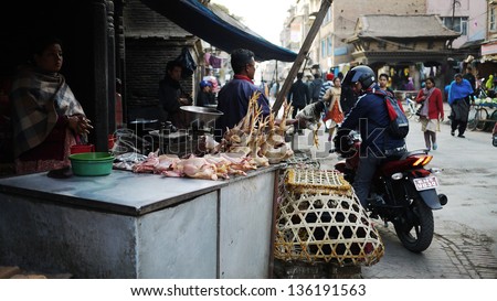 KATHMANDU, NEPAL  - JANUARY 29: hawker sells the chicken in a crowed market in patan area on 29 January 2010. The United Nations list Nepal as one of the Least developed country in the world