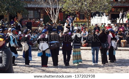 LIJIANG, CHINA - FEBRUARY 20: Nakhi women dance around the square in Lijiang on Feb 20 2012. Nakhi people are an ethnic group inhabiting the foothills of the Himalayas in Yunnan