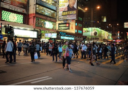 HONG KONG -APRIL 28: the crowd people cross in MongKok on April 28, 2013 in Hong kong. MongKok is one of the neon-lighted places in Hong Kong. It\'s run 24 hour over night and many ads boards.