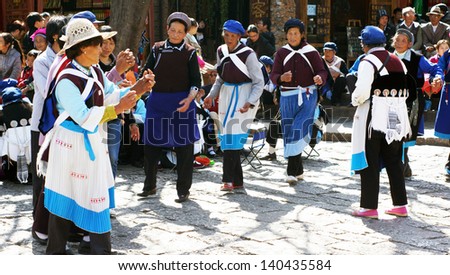 LIJIANG, CHINA - FEBRUARY 20: Nakhi women dance around the square in Lijiang on Feb 20 2012. Nakhi people are an ethnic group inhabiting the foothills of the Himalayas in Yunnan