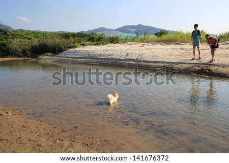 HONG KONG -MAY 1: the couple bring their dog walking in wetland in hong kong on May 1 2013. Wetland, one of important natural landscape is still remained, even hong kong is high developed city.