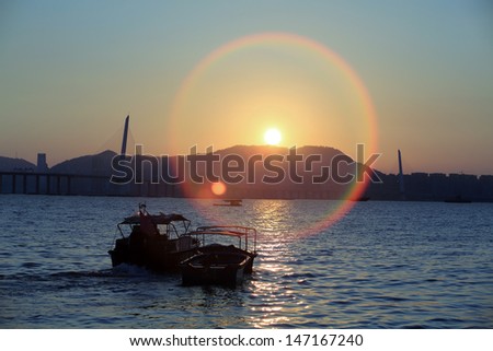 Hong Kong scenes,fishing boat pass through the sun blast Deep Bay sea 