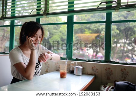 Girl look at watch, waiting someone who late with no patience in cafe