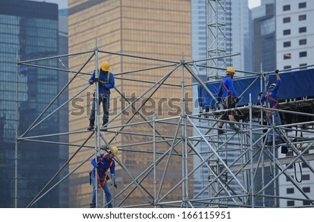 HONG KONG NOVEMBER 30: the unidentified workers are scaffolding on the site in the city surrounding by skyscrapers in Central on 30 nov 2013. Oversea labors are welcomed to HK as the shortage.