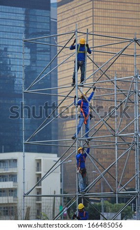 HONG KONG NOVEMBER 30: the unidentified workers are scaffolding on the site in the city surrounding by skyscrapers in Central on 30 nov 2013. Oversea labors are welcomed to HK as the shortage.