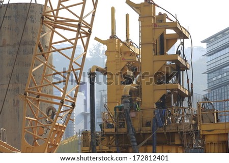 HONG KONG - OCT 25:  the unidentified workers are near the machine on the site in the city in HongKong on October 25, 2013 . Oversea labors are welcomed to HK as the shortage.