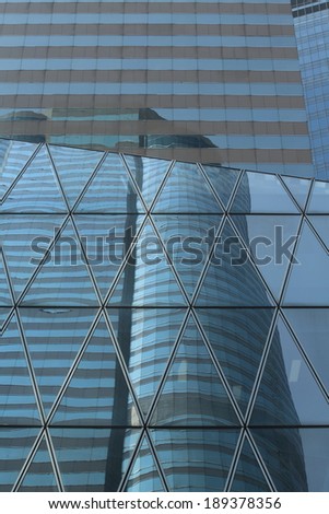 Collage of reflection :different glass building show the tall skyscraper at hong kong finance zone, background, Abstract triangles windows with the reflection of other buildings