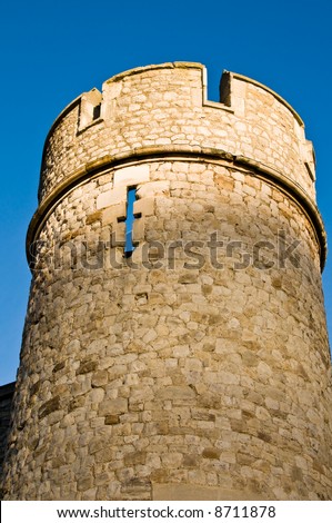 Round stone defence tower with castellations and arrow slits