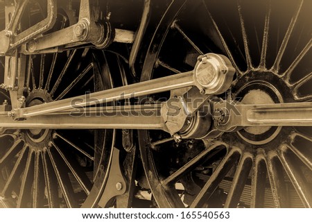 Steam train wheels with attached piston and connecting rods. Vintage sepia effect. Horizontal format.