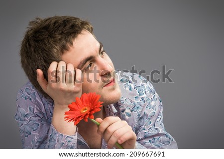 Portrait of man holding red flower , isolated on grey background
