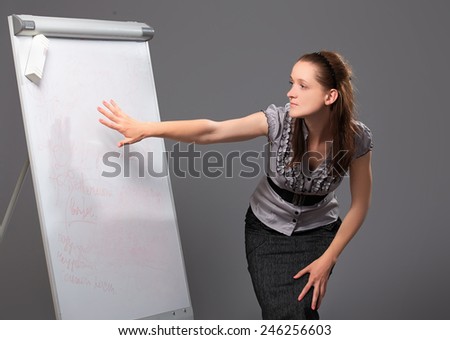 Businesswoman standing next to flip board and pointing hand