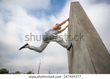 young man jumping on the walls sport parkour