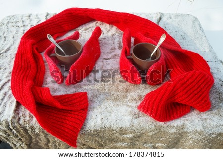 Tea with knitted gloves and a scarf