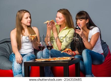 Three girls with wine and pizza