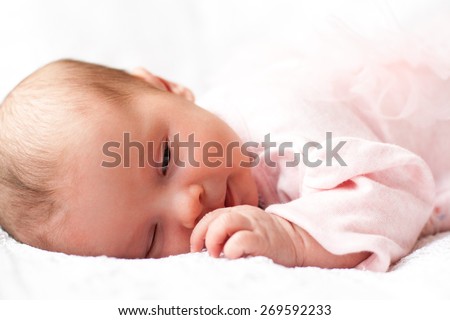 new born baby sleeping on texture blanket, lying on blanket, closed eyes, light pink dress
