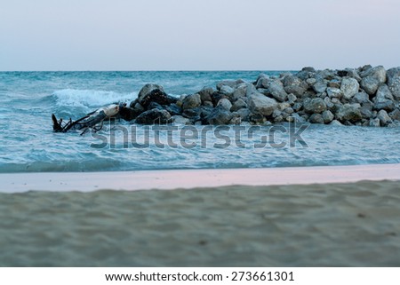 view of sea and sand beach with stones at sunset in the evening, sea tide, natural photo, Bibione, Italy