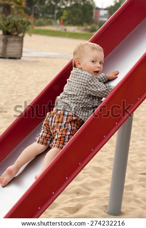 baby on kids slide on sand beach, child on slide, summer time, active baby time, Bibione, Italy