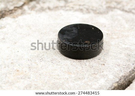 Vintage old hockey puck on stone background, used rubber puck, Ice Hockey World Championships, used implements, natural and real photo
