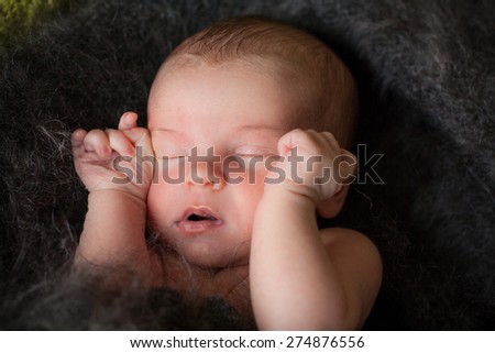 new born baby is sleeping in downy shawl, lying baby, eyes are closed, open mouth