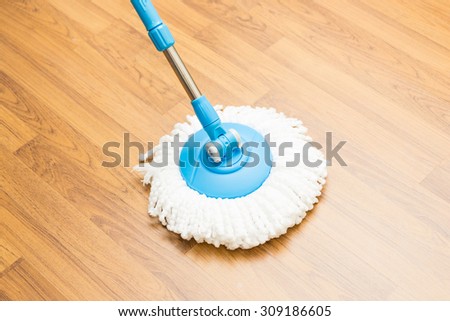 Cleaning by use modern mop on laminated wood floor.