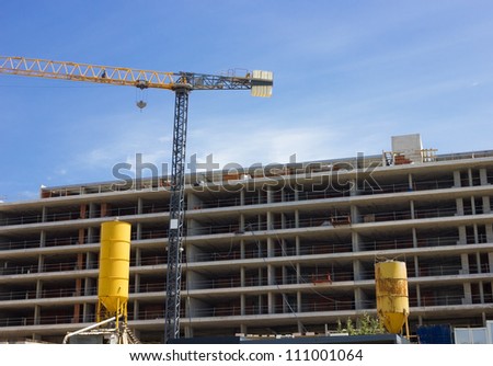 Yellow cisterns and crane tower on the Highrise Construction Site