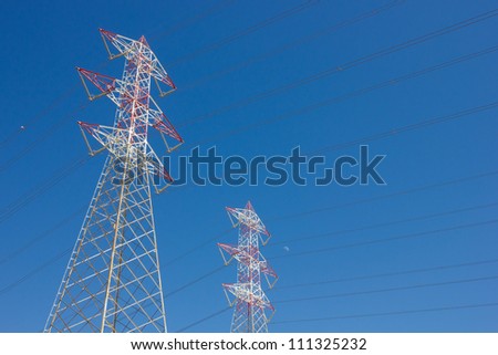 long lines of power-line tower stretching across a blue Sky
