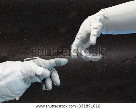 Astronaut hand and robotic hand on outer space background. Elements of this image furnished by NASA.