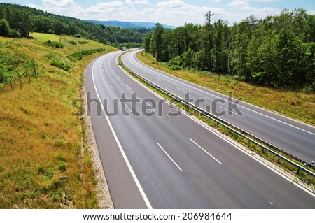Empty highway between forests, at the end of the highway white truck, view from above