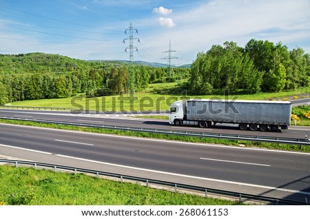 A country landscape with highway and ride the truck. Despite the highway leading power lines to pylons of electric power lines. View from above.