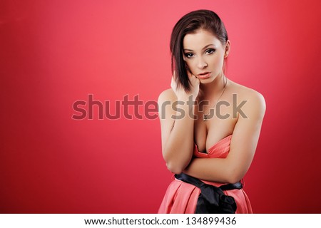 Portrait of a beautiful girl in a pink gauzy dress on light background/ Girl shows emotion, anger, anxiety, smile, joy