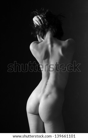 Naked beautiful woman relating to the white and the black background in the gymnastic figure