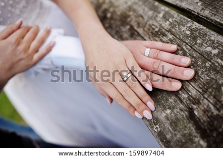 Wreathed hands of lovers. Hands of spouses being in the amorous touch on the wooden railing of stairs