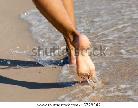 Women\'s barefoot legs on the beach