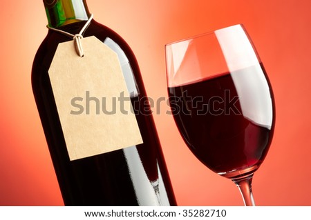 Glass and bottle of red wine with tag
