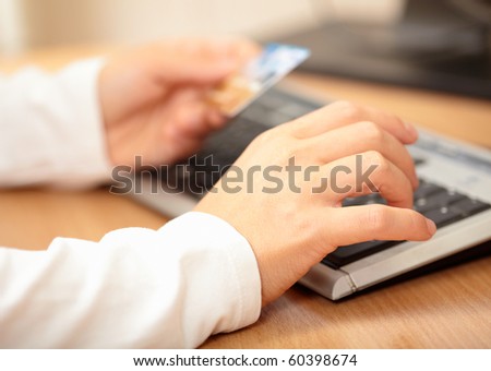 Hands holding credit card and keyboard. Shallow DOF