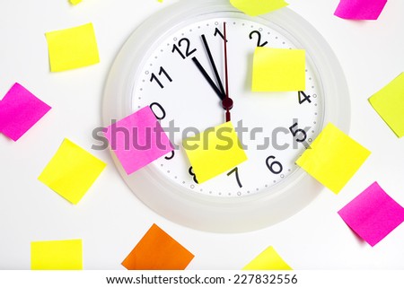 White clock with pink, yellow,green,orange sticky paper, memo sticker  isolated on grey background.