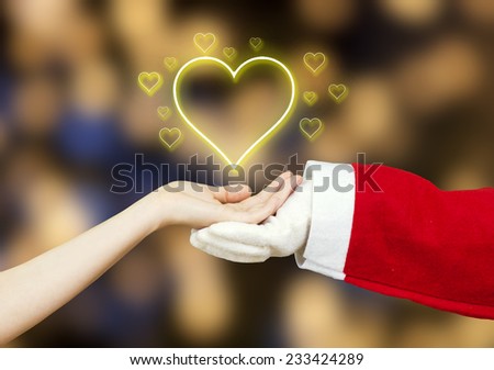 Santa Claus hand in white glove holding together with a woman hand  little hearts surrounding a big heart isolated on green background.